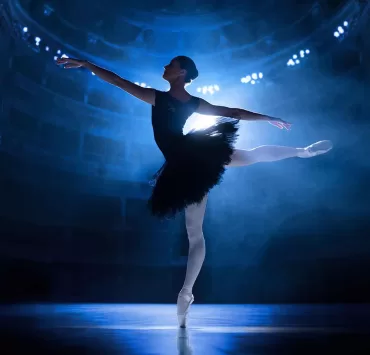 Ballerina in controluce illuminata da un faro sul palcoscenico, metafora delle scelte che precedono una campagna Google Ads.