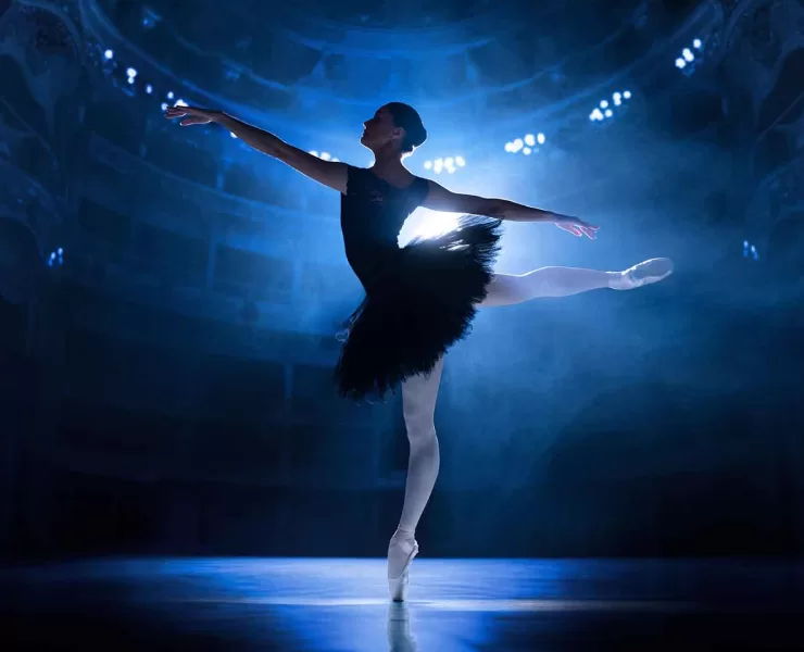 Ballerina in controluce illuminata da un faro sul palcoscenico, metafora delle scelte che precedono una campagna Google Ads.